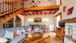 A living room with a wooden staircase, a sofa set, a coffee table, and a fireplace. - Large and beautiful detached house in a quiet and relaxing setting (Ruederbach)