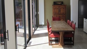 Ein Essbereich mit einem Holztisch, roten Stühlen, einem Schrank und einem Kühlschrank.