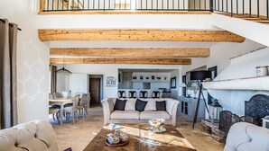 A spacious living room with a high ceiling, a dining area, and a kitchen. - VILLA SOLEIL D'OR GOLFE DE ST TROPEZ4*, swimming pool at 29° all year round, 180° view (Cavalaire-sur-Mer)