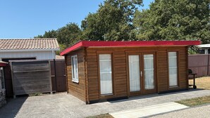 A small wooden structure with a red roof, a sliding door, and a window. - PAX HOUSE - at the lake Hourtin - 6 beds (Hourtin)