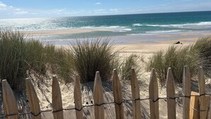 A beach with a wooden fence in the foreground and a clear view of the ocean. - PAX HOUSE - at the lake Hourtin - 6 beds (Hourtin)