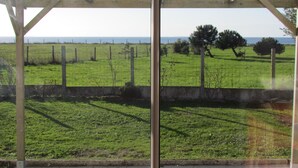 A covered outdoor area with a view of a grassy field and trees. - IN FRONT OF THE SEA. ALMOST PENERF ISLAND. WIRELESS. (Damgan)