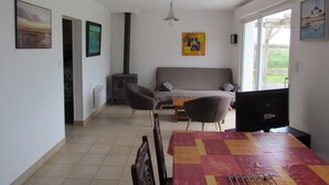 A living room with a sofa, chairs, a table, a fireplace, and artwork on the walls. - IN FRONT OF THE SEA. ALMOST PENERF ISLAND. WIRELESS. (Damgan)