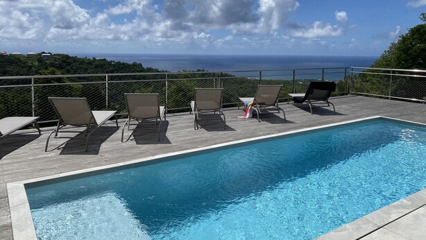Una piscina con lettini e vista sull'oceano.