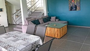Un soggiorno moderno con un divano grigio, un tavolino da caffè decorato e una parete di colore blu.