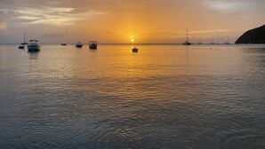 Mare calmo con barche al tramonto.