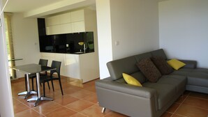 Un espace de vie moderne avec un canapé gris et une table à manger avec des chaises.