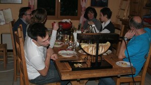 A group of people dining at a wooden table with a bread oven in the center. - GUEST ROOM 2 PEOPLE IN PRETTY SAVOYARD HOUSE (Mercury)