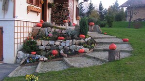 A house with a stone garden bed, a wooden staircase, and a wooden door. - GUEST ROOM 2 PEOPLE IN PRETTY SAVOYARD HOUSE (Mercury)
