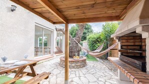 A patio with stone flooring, wooden benches, a grill, and a hammock. - Villa Olivier with a private pool—10 minutes from the beach (Bompas)