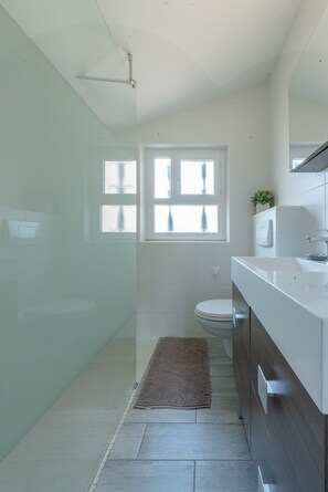 Een douche, een haardroger, handdoeken, toiletpapier