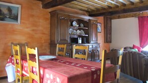 A dining area with a wooden table, chairs, and a cabinet with dishes.