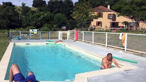 A rectangular swimming pool with a tiled deck, a fence, and a house in the background. -  ... Charming Residence in the heart of Gascony, with Jacuzzi & sauna (Estipouy)