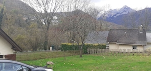A residential area with houses, a fenced yard, and a mountain backdrop. - Ideal for hikers (Laruns)