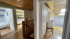 A room with a wooden ceiling, a bed with a white bedspread, a small table with a lamp, and a chair. - House with private swimming pool, in the heart of south-west (Thézac)
