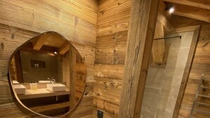 A wooden cabin bathroom with a wooden vanity, a round mirror, and a shower area. - Chalet Aguila 5***** (NEW) sleeps 12 - XXL. jacuzzi and panoramic sauna (Bolquère)
