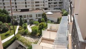 Un immeuble résidentiel à plusieurs étages doté d’un jardin sur le toit et d’une terrasse couverte.
