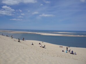 Une plage de sable où des gens prennent des bains de soleil et se détendent.