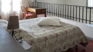 A bedroom with a bed, a desk, a chair, and a balcony with a railing. - Charming Gites in Provence, with pool  (Vaison-La-Romaine)