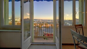 An open balcony with a view of a cityscape, including buildings and a river.