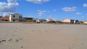 Ein Strand mit Gebäuden im Hintergrund.
