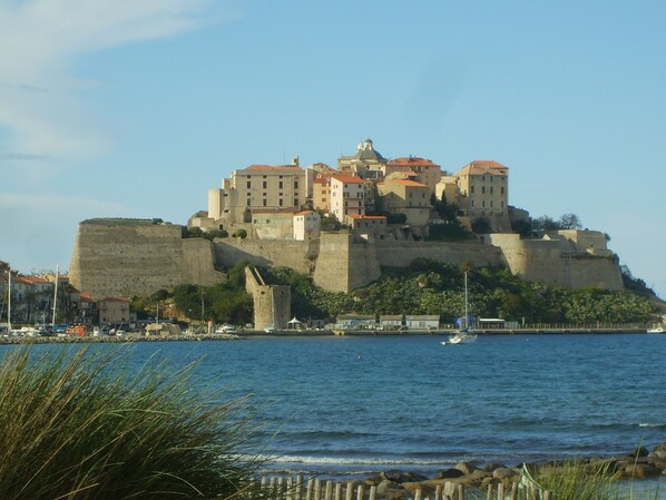A historic fortified castle with multiple buildings atop a hill overlooking a body of water. - 2-room apartment, new with terrace and sea view sleeping 2 to 4 (L'île-Rousse)
