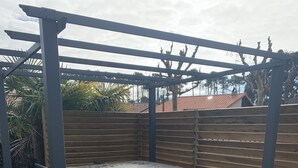 A hot tub under a pergola on a wooden deck with a wooden fence in the background. - RENTAL HOUSE MESSANGES near beach south coast of Landes  (Messanges)