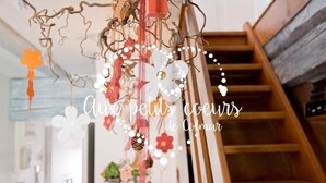 A staircase with a wooden handrail and a decorative hanging ornament above it. - Wonderful apartment in the heart of Little Venice (Colmar)