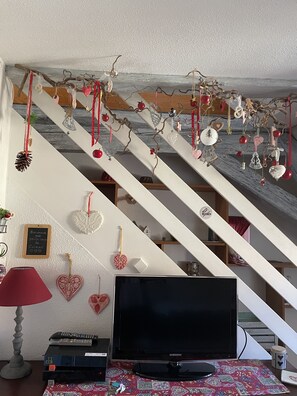 A staircase with a TV and remote control on the landing.