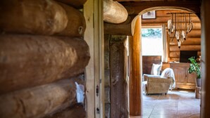 Een houten interieur met een kroonluchter, een bank en een plant.