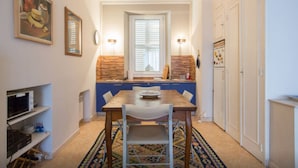 Una cocina compacta con una mesa de comedor, sillas y un tapete estampado.