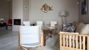 Una sala de estar con chimenea, un sofá y una mesa de centro.