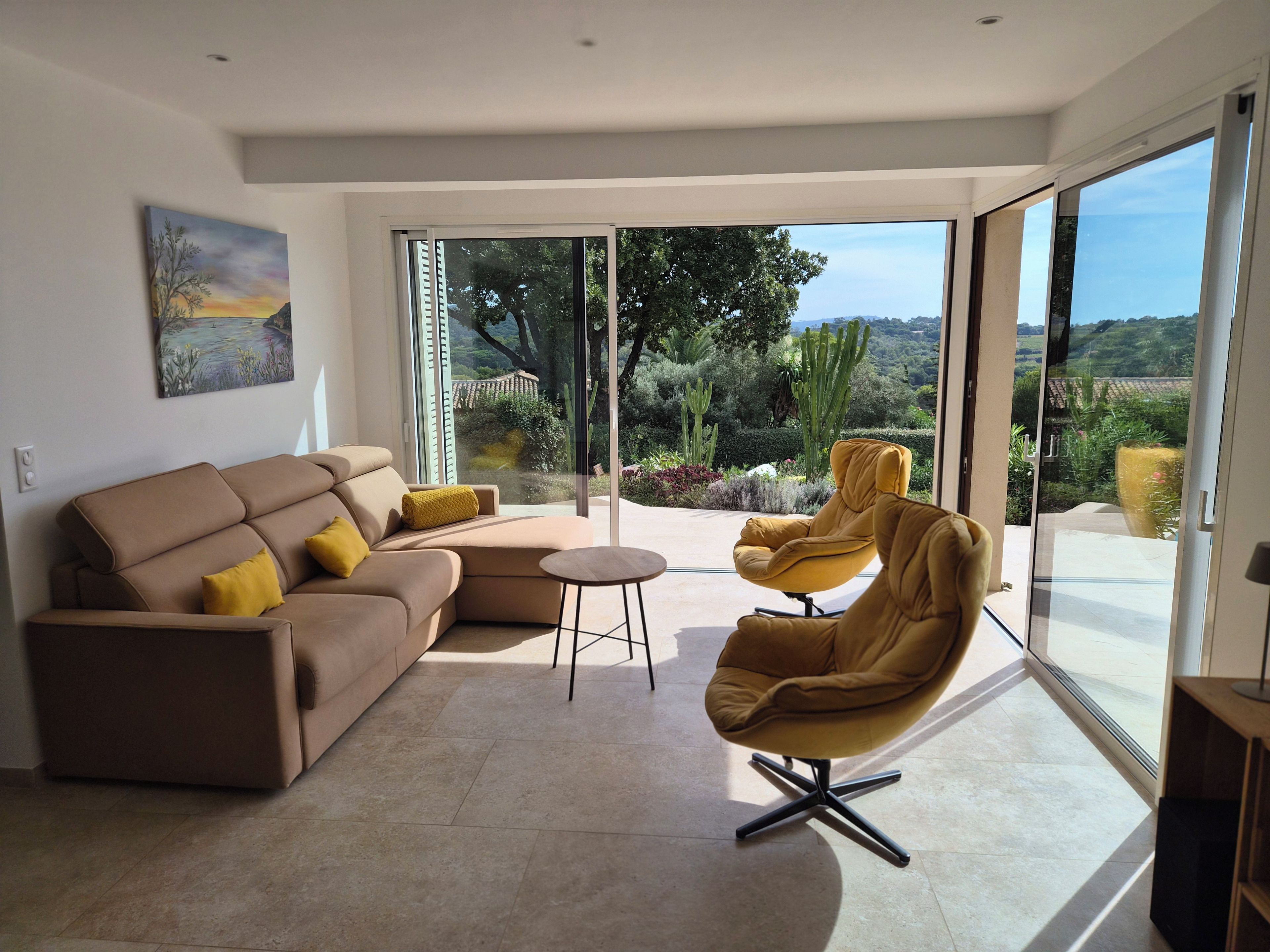 Un salon moderne avec un canapé, un fauteuil et une petite table.