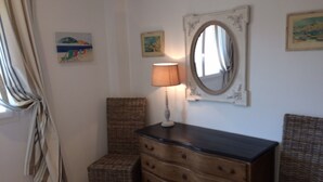 A room with a wooden dresser, a chair, a lamp, and a mirror on the wall. - Provencal bastide with heated pool and air conditioning in Plascassier (Mouans-Sartoux)