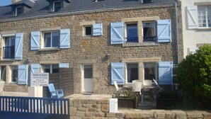 Un bâtiment en pierre doté de nombreuses fenêtres et d’une enseigne indiquant qu’il s’agit d’une résidence de vacances.