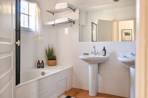 Bathtub, hair dryer, towels, toilet paper