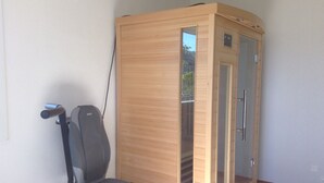 Um armário de madeira com porta de vidro, uma cadeira e um cabo.