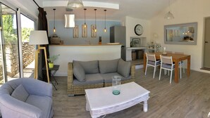 Un grand espace de vie comprenant un canapé, une table à manger et une cuisine à l’arrière-plan.