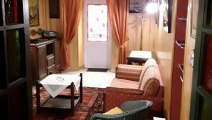A compact room with a bed, a small table, a chair, and a sofa.