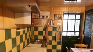 A kitchen with a checkered tile backsplash, a sink, a window, and a table with chairs.