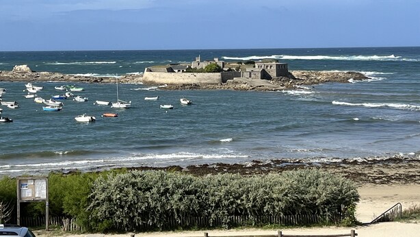 A coastal view with a fortified structure, boats, and a sandy beach. - Loriot1 apartment sea view on the fort blocked, ploemeur  (Ploemeur)