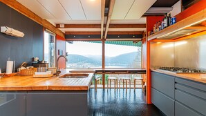 Una cocina moderna con una isla grande, vigas de madera y vistas a montañas.