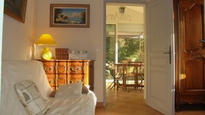 A room with a bed, a wooden dresser, a lamp, and a painting on the wall.