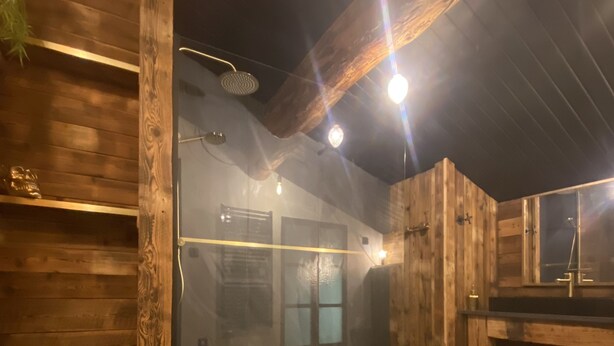 Un intérieur en bois comprenant un sauna, des murs en bois et un banc.