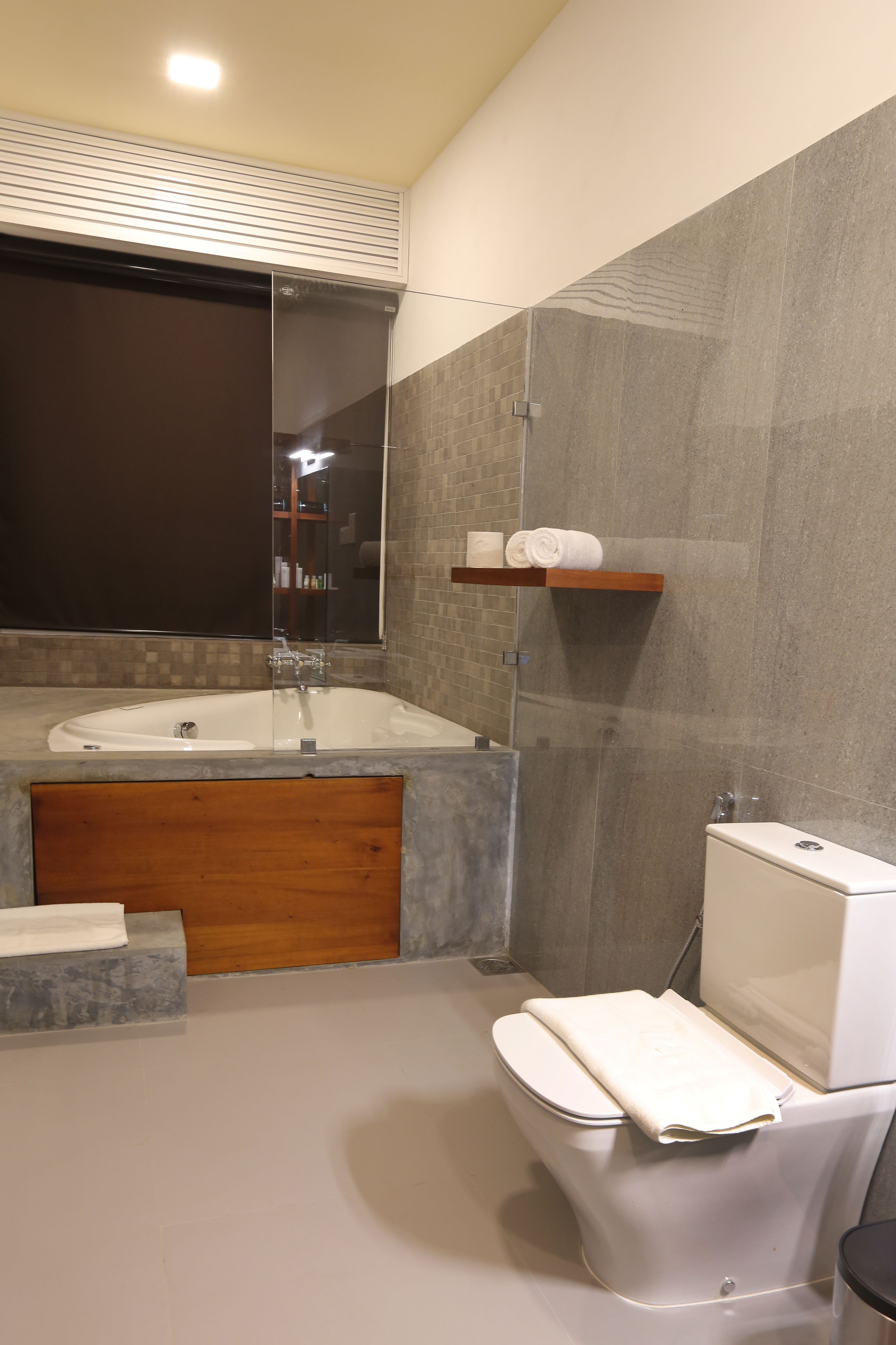 A modern bathroom with a freestanding bathtub, a toilet, and a vanity with a mirror.