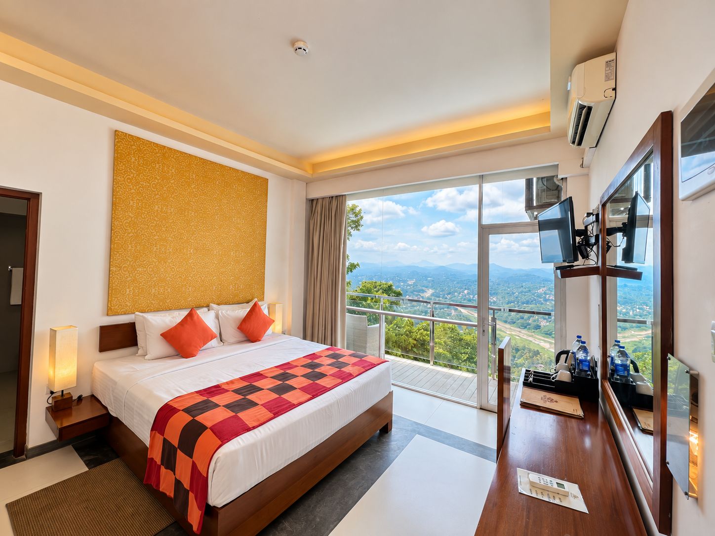 Une chambre d’hôtel avec un grand lit, un balcon donnant sur la ville et une télévision.