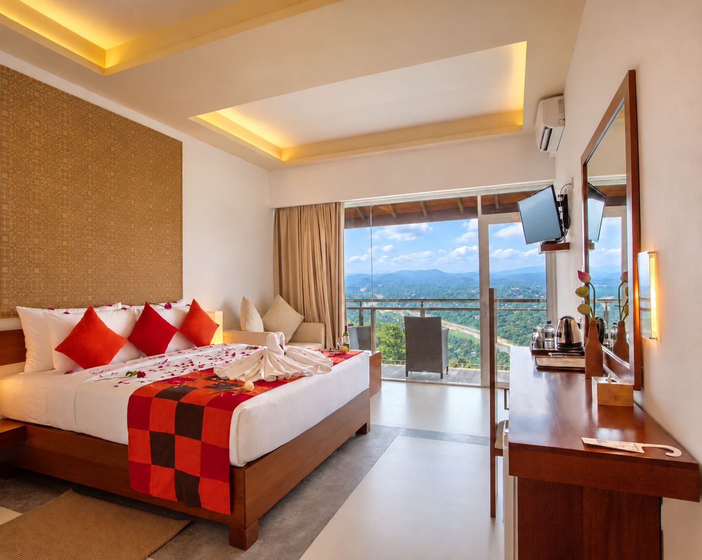 Habitación de hotel con una cama grande, escritorio, televisor y balcón con vistas.