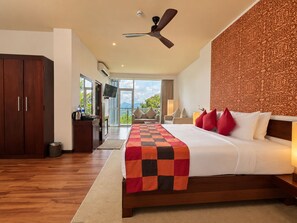 A hotel room with a bed, a desk, a ceiling fan, and a view of the outdoors. - Mount Blue Kandy (Kandy)