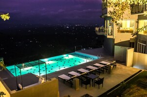 Una piscina en la azotea con vistas despejadas de la ciudad de noche.