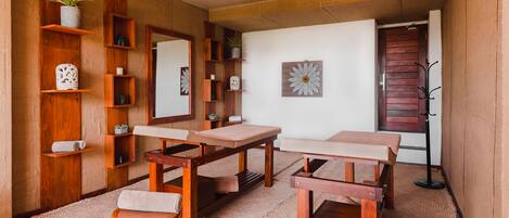 A room with wooden furniture, a mirror, a potted plant, and a wall-mounted artwork.